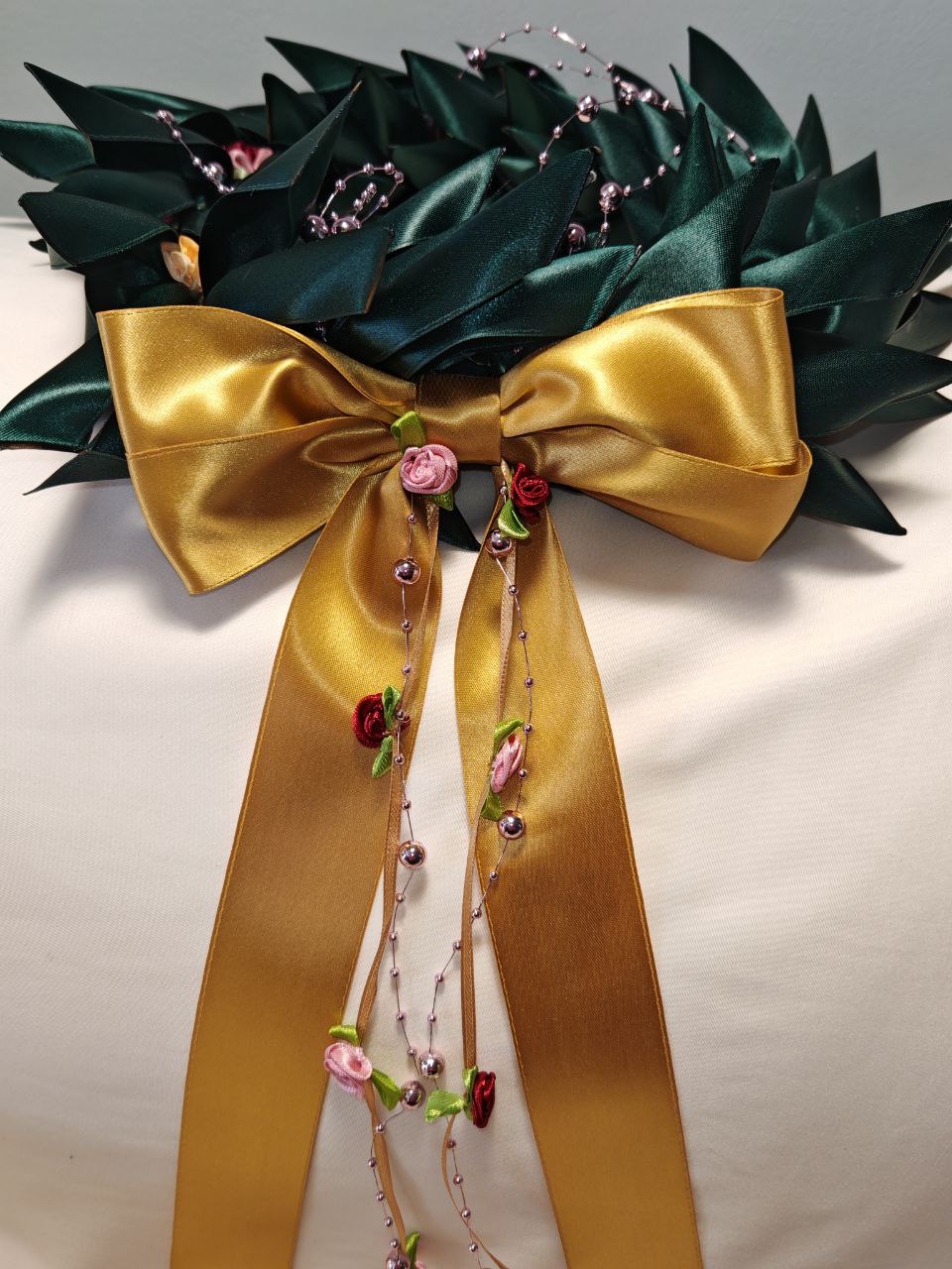 Corona d'alloro con filo di roselline e fiori decorativi