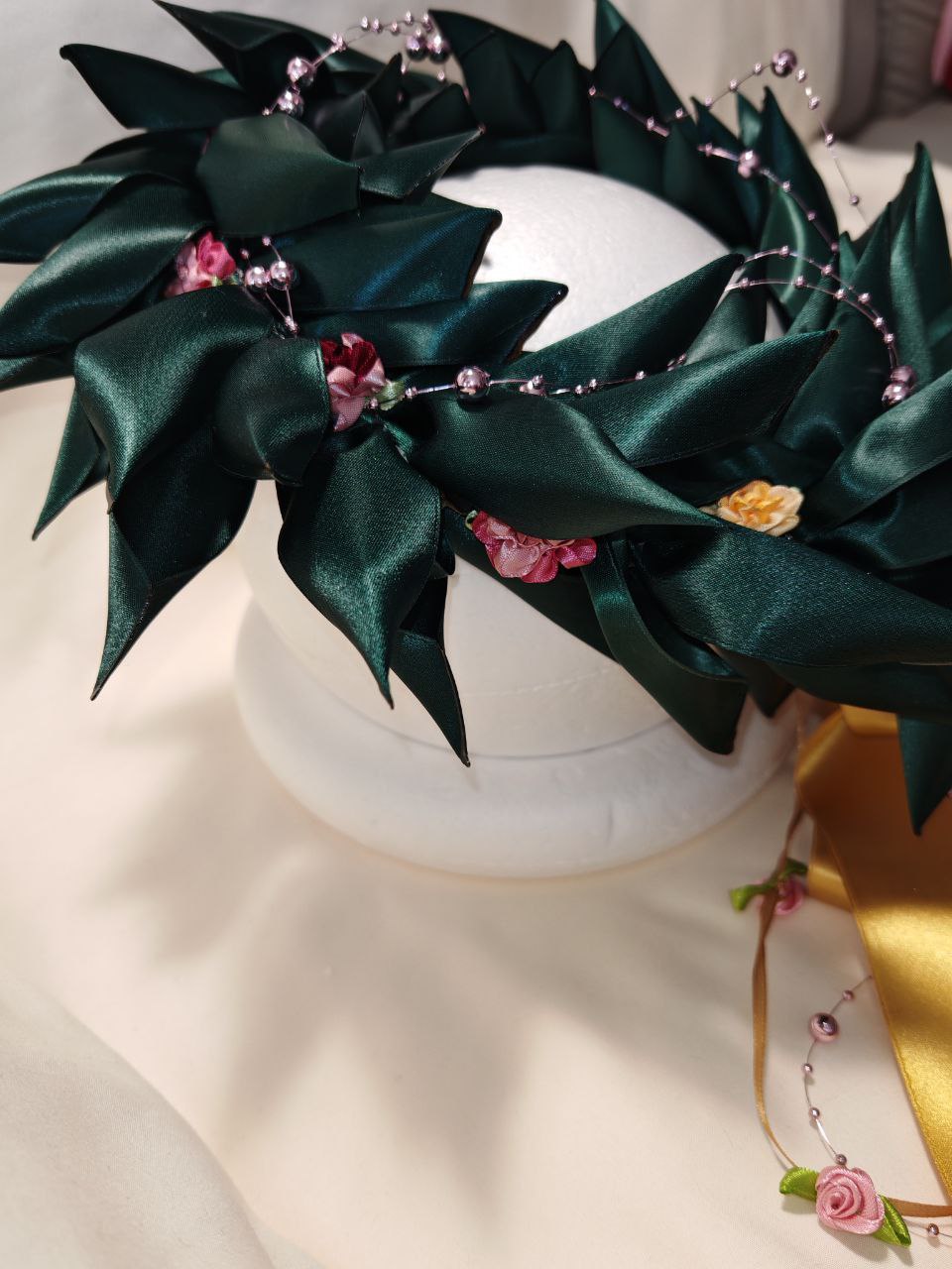 Corona d'alloro con filo di roselline e fiori decorativi
