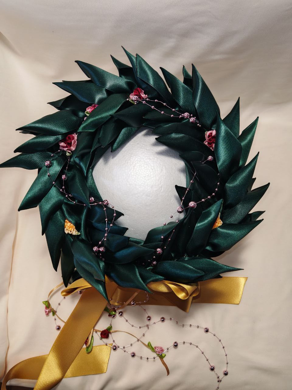 Corona d'alloro con filo di roselline e fiori decorativi